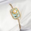 316L Çelik Zincir Turkuaz Mineli Sanatsal Portre İnci Detaylı Papatya Model Gold Renk Kadın Bileklik